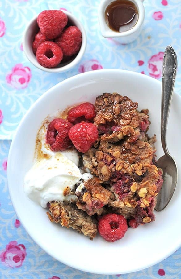 Portion baked oatmeal served with yoghurt and fruit in a small bowl