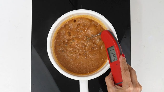 Testing the temperature of salted caramel sauce with digital thermometer