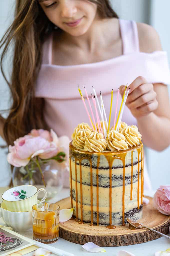Girl adding candles to Salted Caramel birthday cake