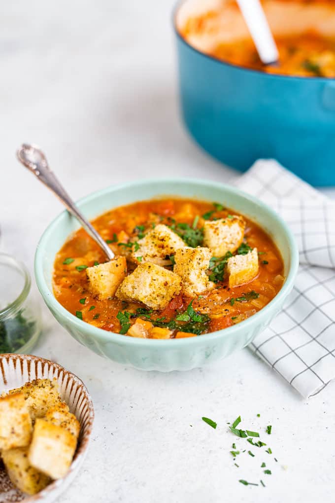 Bowl of minestrone soup topped with croutons