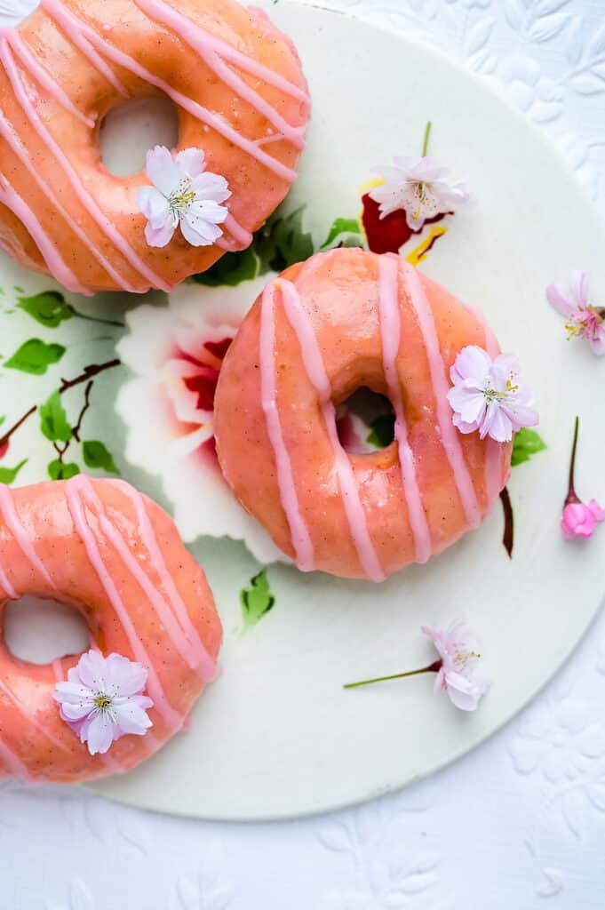 Donuts with pink glaze on a ceramic board