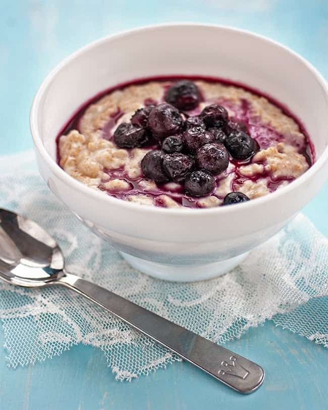 Bowl of vegan coconut oatmeal with blueberry compote