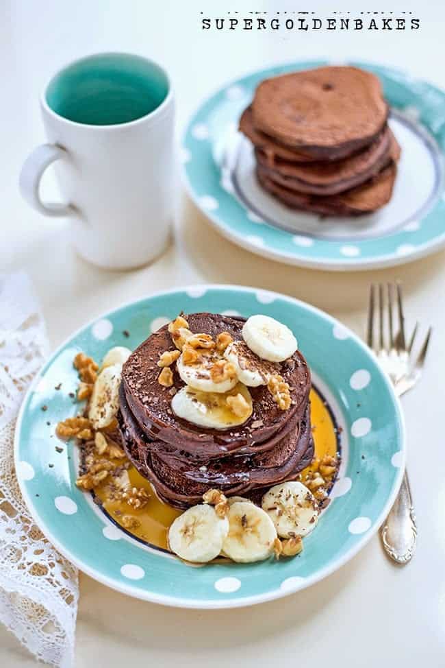 chocolate pancakes served with bananas and nuts and drizzles with maple syrup 