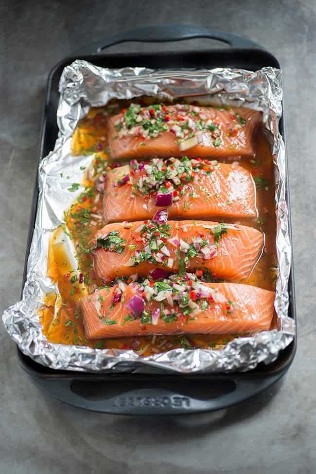 salmon fillets with asian marinade in a foil-lined roasting tray
