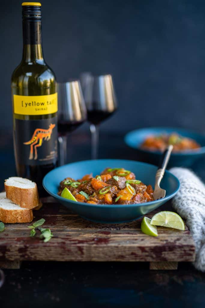 Bowl of beef stew with wine on a rustic table 