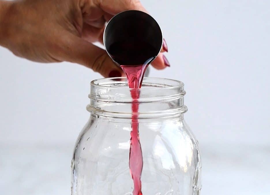 adding cranberry juice to cocktail shaker