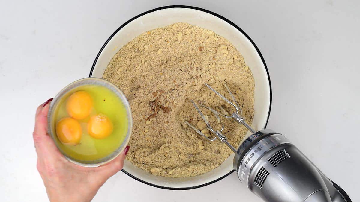 Adding eggs to cake batter in bowl