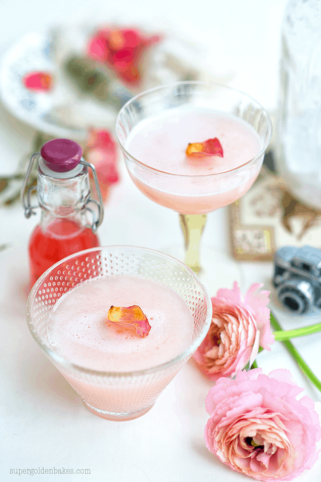 Two glasses of rhubarb cocktails garnished with rose petals