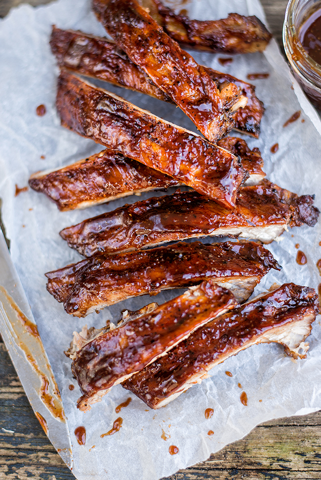 These sticky dry-rubbed ribs with bourbon-spiked BBQ sauce are totally irresistible! Cook in the oven or your barbecue. 