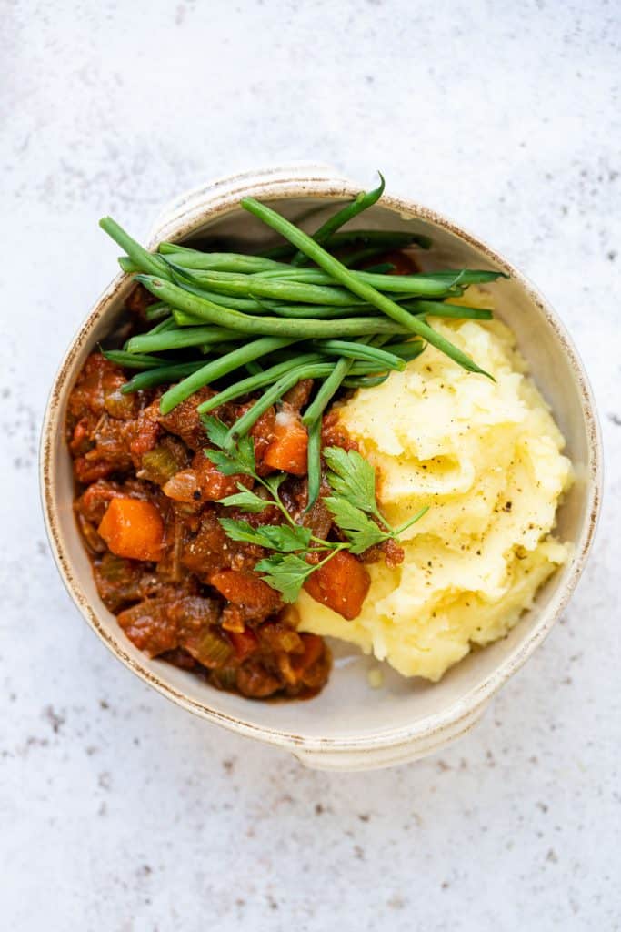 Greek stifado served with mashed potatoes and green beans
