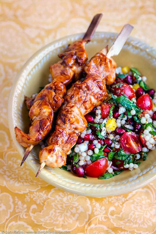 Jewelled giant couscous with grilled chicken skewers in a bowl