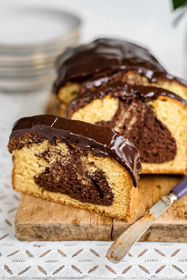 Marble cake with chocolate glaze cut into slices on a wooden board