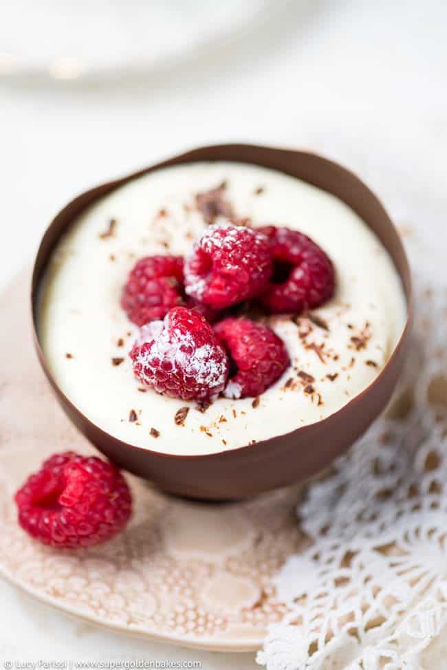 Chocolate cup containing white chocolate mousse topped with fresh raspberries