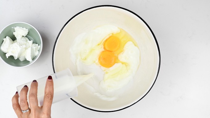 milk and eggs in a mixing bowl