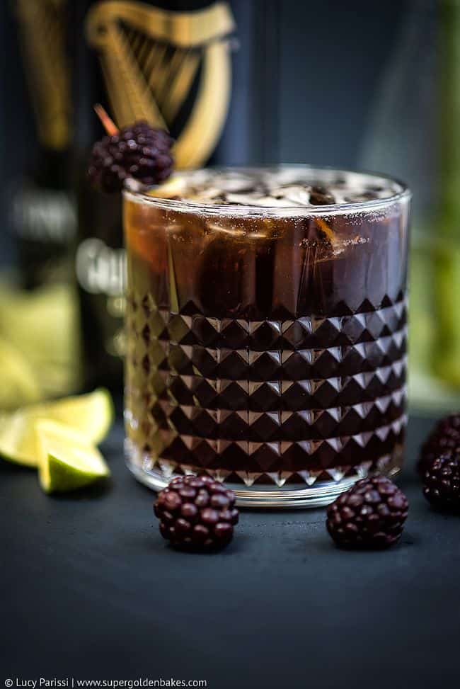 Guinness cocktail served on the rocks garnished with blackberries
