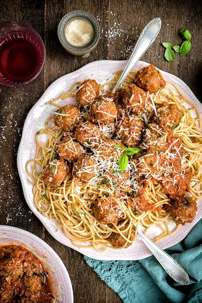 Platter of spaghetti and meatballs with grated Parmesan