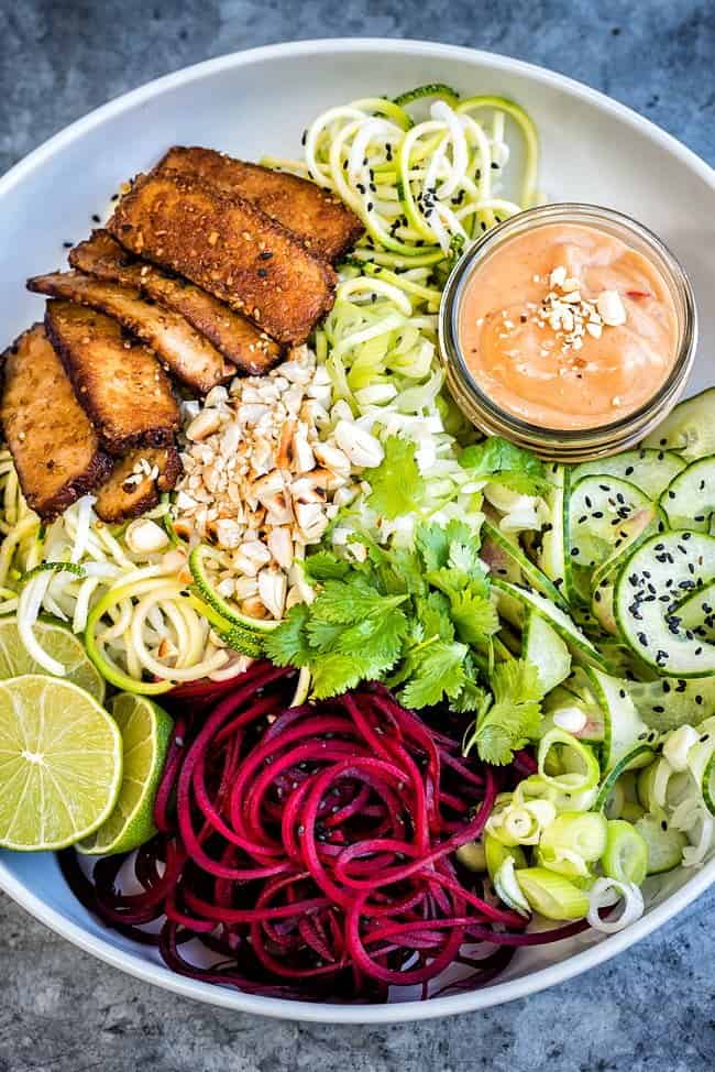 A medley of spiralized vegetable noodles with smoked tofu and spicy peanut sauce - a healthy and delicious vegan recipe.