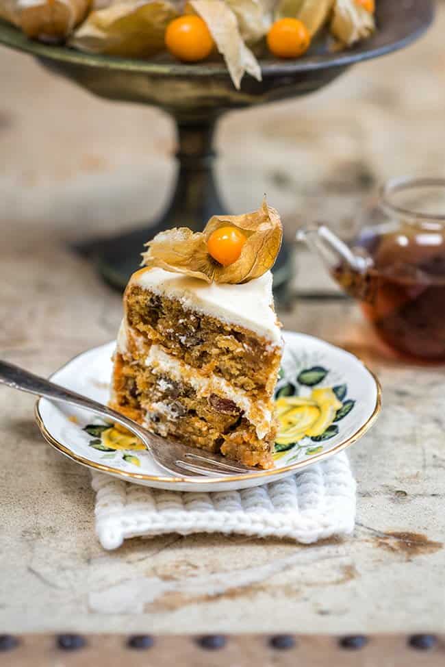 A spectacular layered carrot cake recipe with chai infused raisins, rich mascarpone frosting and addictive chai tea caramel.