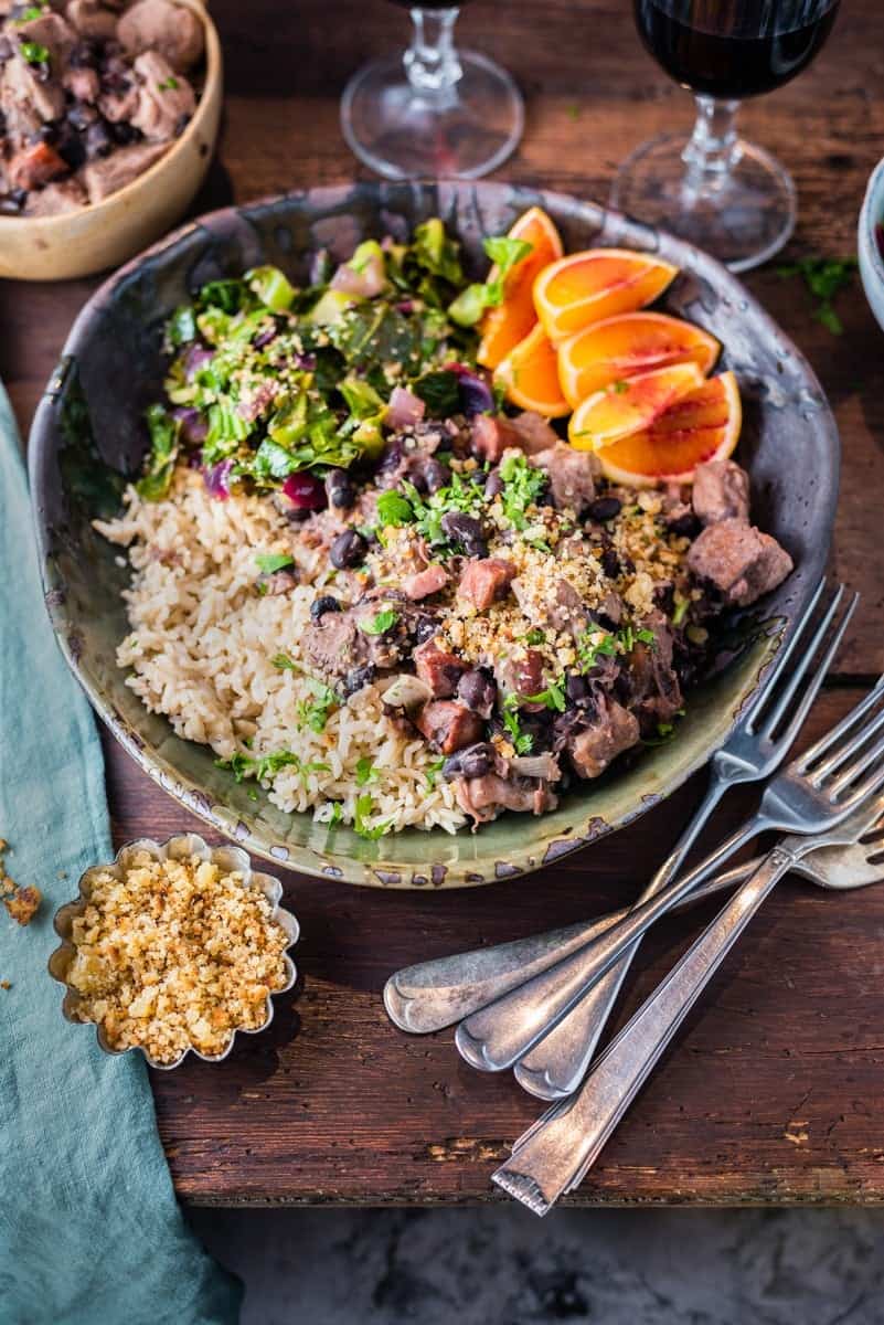 Slow cooker Brazilian feijoada – rich pork stew with black beans served with spring greens, orange wedges and brown rice.