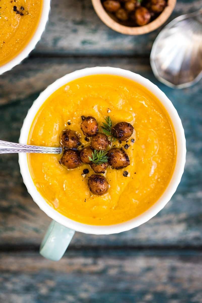 close up on spiced carrot soup garnished with crispy chickpeas