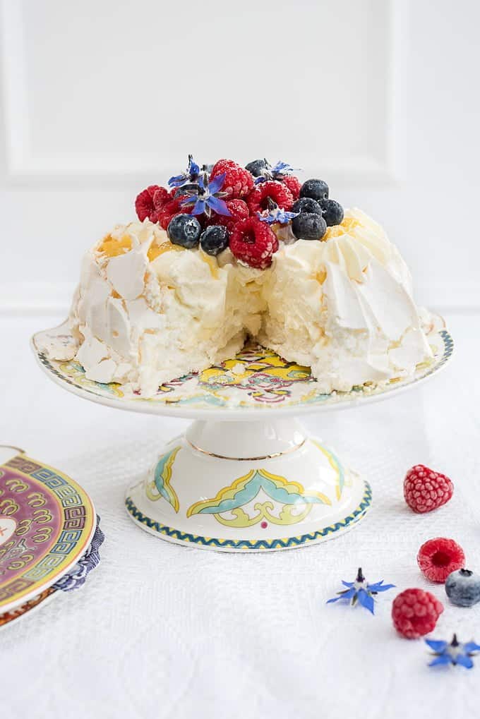 Pavlova crown with whipped cream, lemon curd and fresh berries