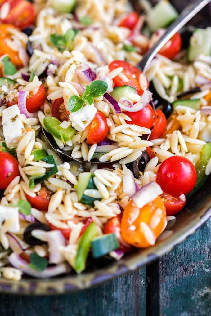 Close up on a bowl of pasta salad made with orzo and vegetables