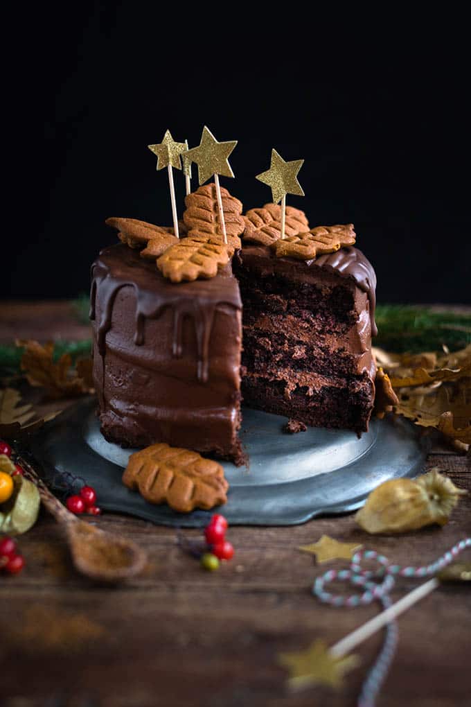 Vegan chocolate and gingerbread layer cake with gingerbread cookie decorations. Perfect for Christmas or birthdays and celebrations.