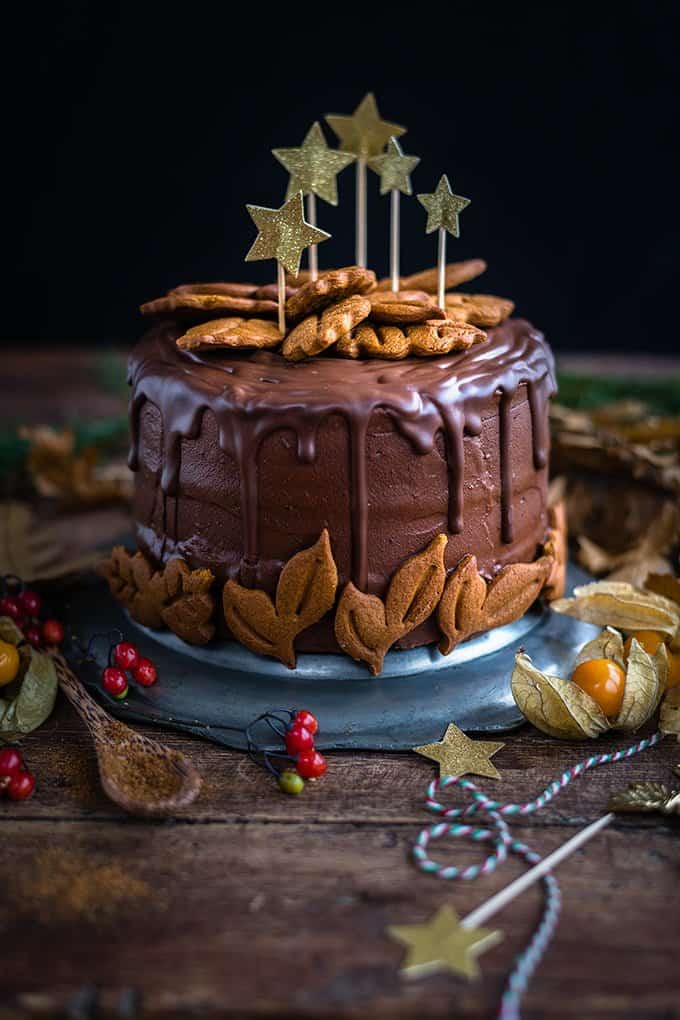 Incredibly delicious vegan chocolate gingerbread layer cake decorated with gingerbread cookies