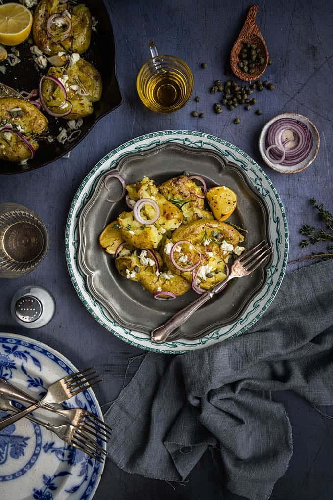 These Greek smashed potatoes are fantastic as a side dish, but can become a main meal if you add some puy lentils or some tinned tuna. The potatoes even taste great reheated the next day or you can turn leftovers into a salad. They are really an all-round winner.