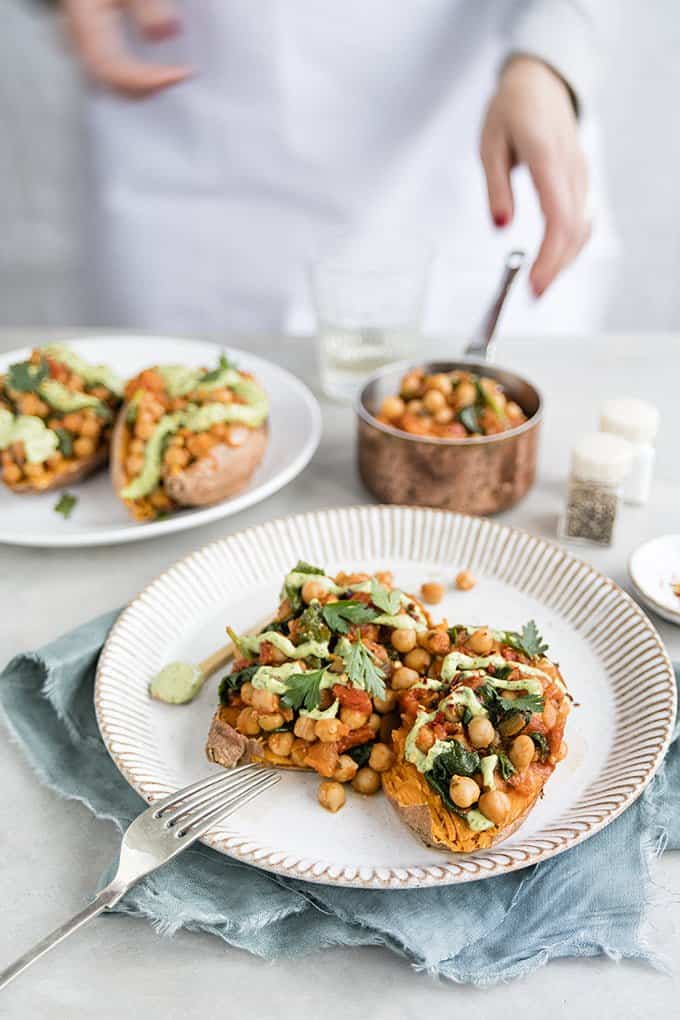 These baked sweet potatoes with spicy chickpeas and green tahini dressing are be ready in 30 minutes – gluten free, vegan, healthy and really satisfying.