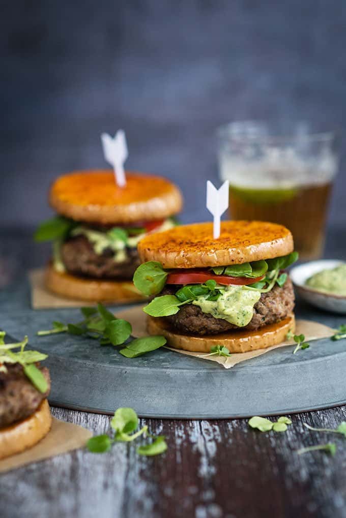 Herby lamb burgers with feta cheese served over butternut squash 'buns' with an addictive green tahini dressing