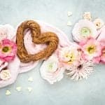 Vegan heart-shaped churros arranged with fresh flowers for Valentine's Day