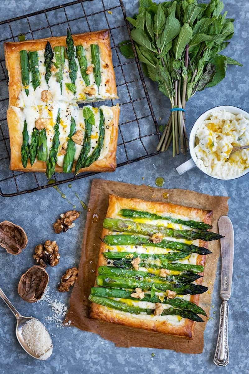 Two puff pastry tarts topped with asparagus