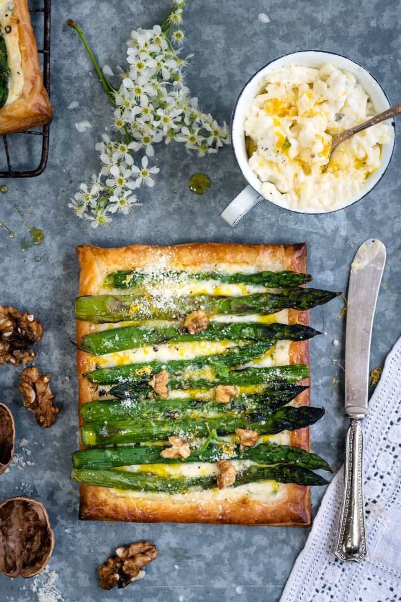 Puff pastry tart filled with cheese and topped with asparagus