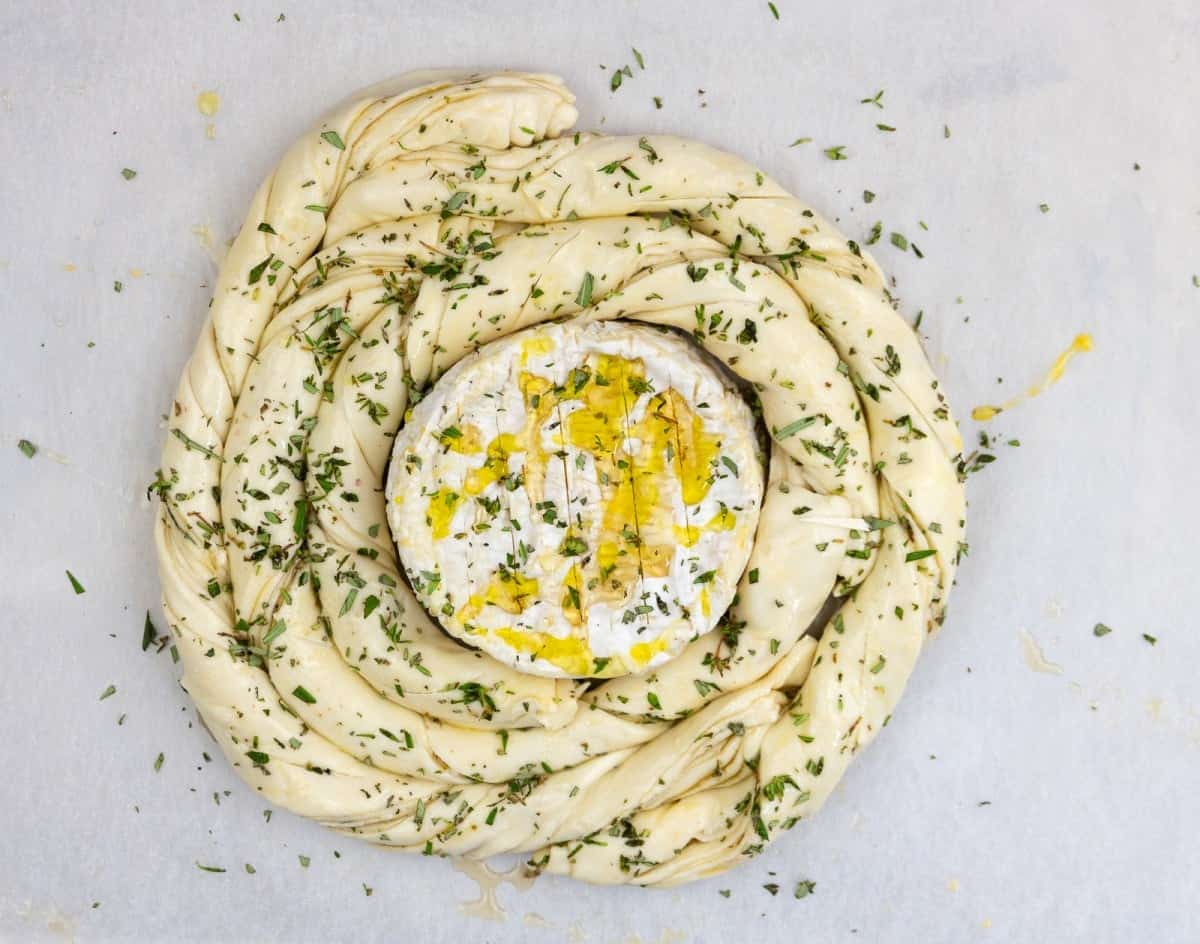 Puff pastry spiral with baked camembert, honey, rosemary and thyme, ready for the oven