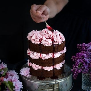 Chocolate layer cake with blackberry buttercream with blackberry syrup drizzled over the top