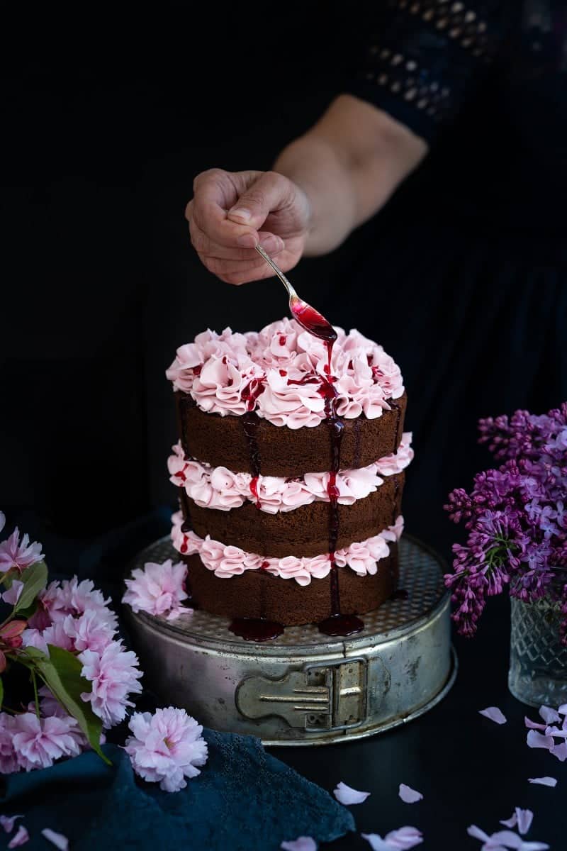 Chocolate layer cake with blackberry buttercream with blackberry syrup drizzled over the top