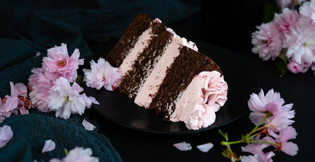 Slice of chocolate layer cake with blackberry Italian buttercream