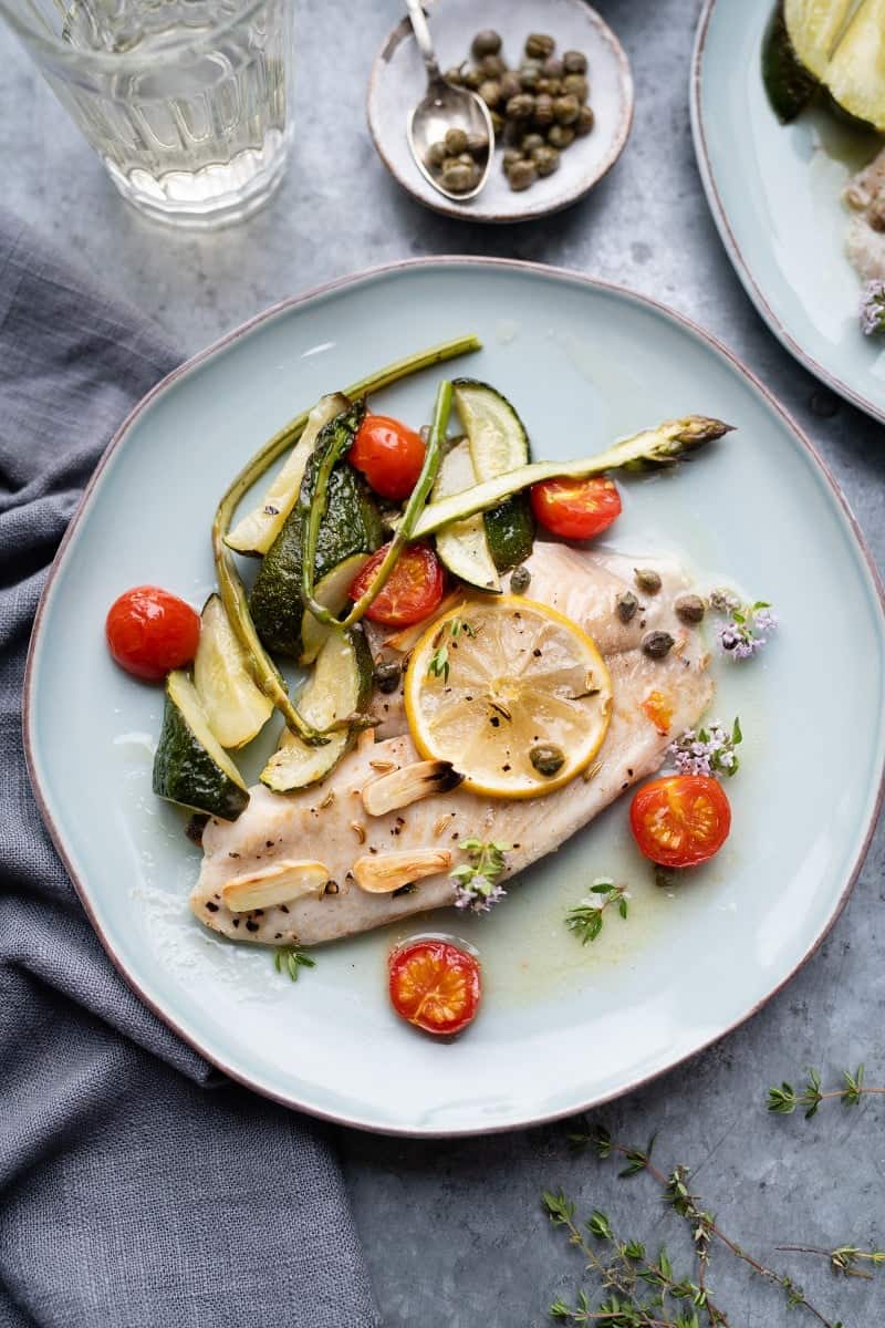 Oven-baked tilapia with vegetables on a plate