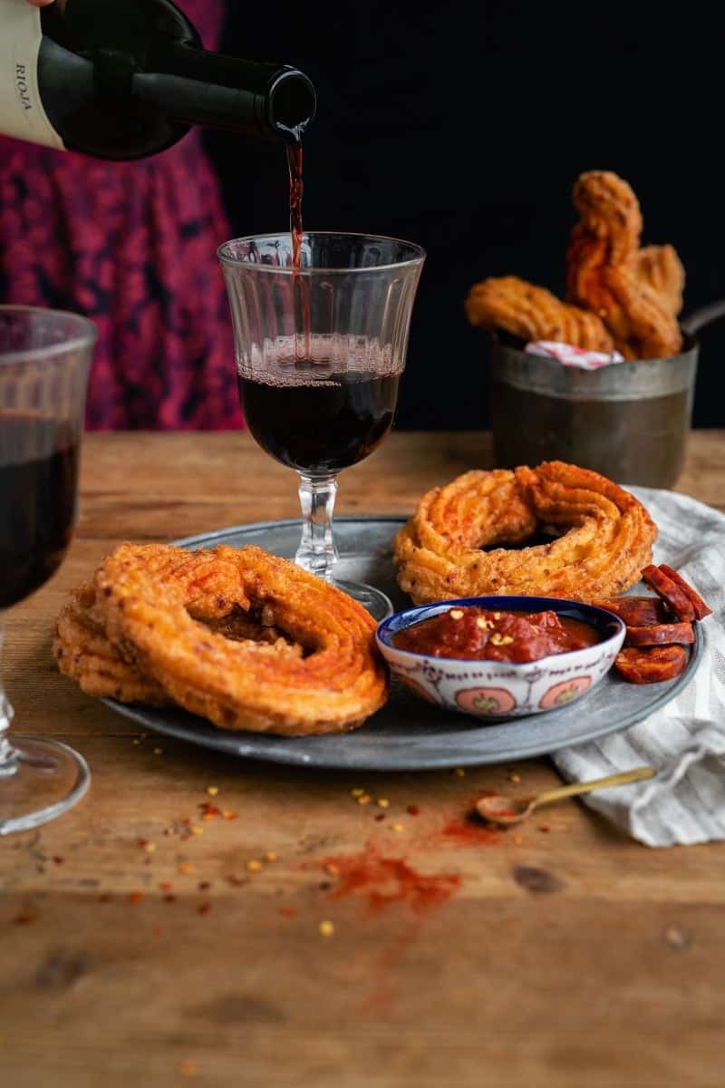 Savoury churros served with tomato dipping sauce and a glass of Rioja
