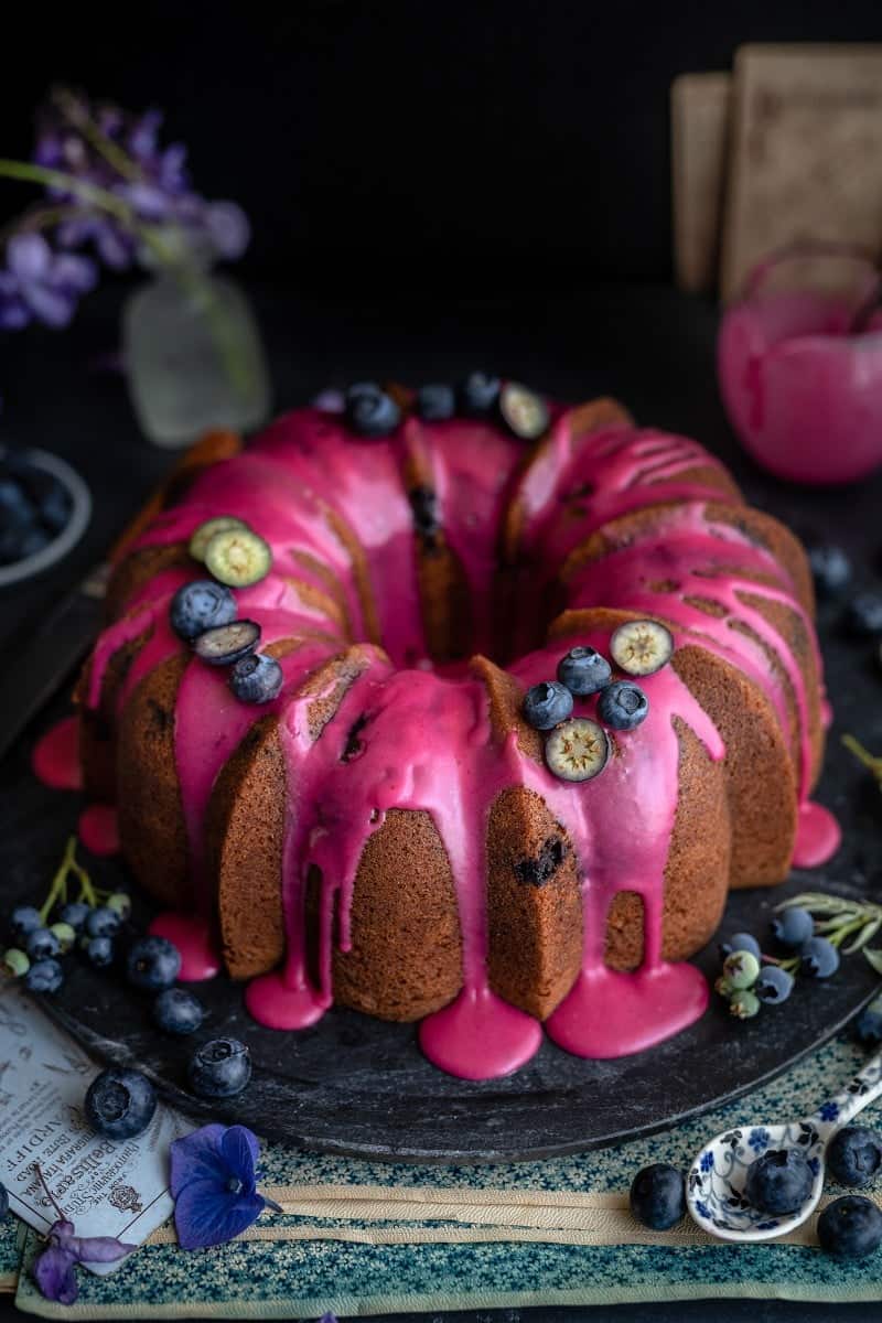 Blueberry Pound cake on a marble board with pink glaze