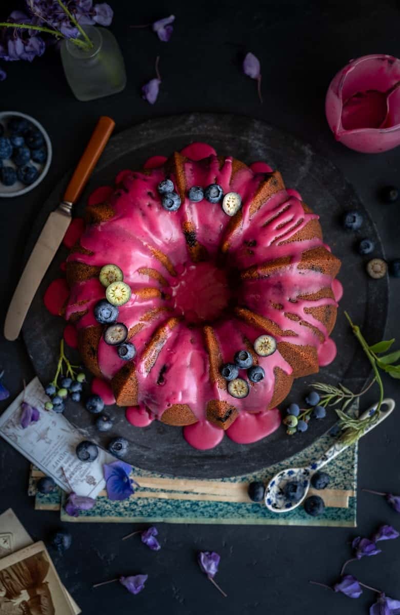 Beautiful blueberry pound cake with lemon glaze and fresh blueberries shown from above