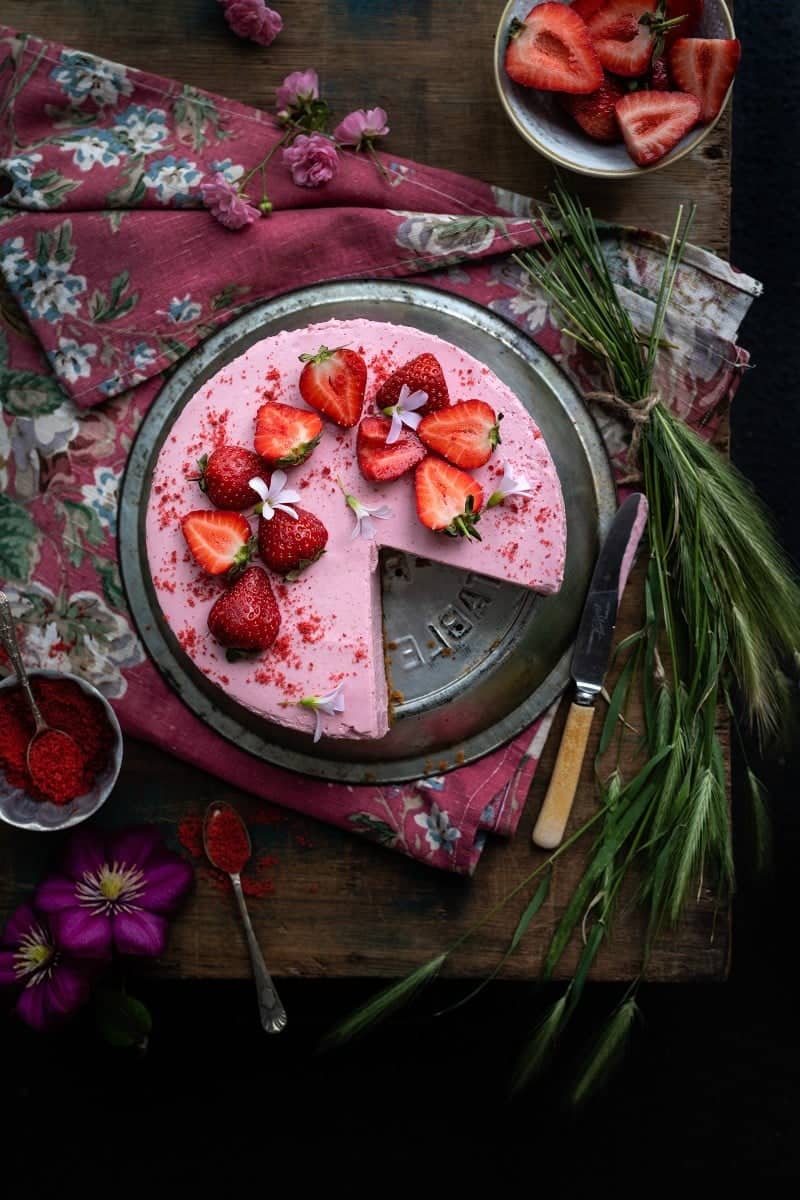 Sliced strawberry cheesecake on a vintage pie plate