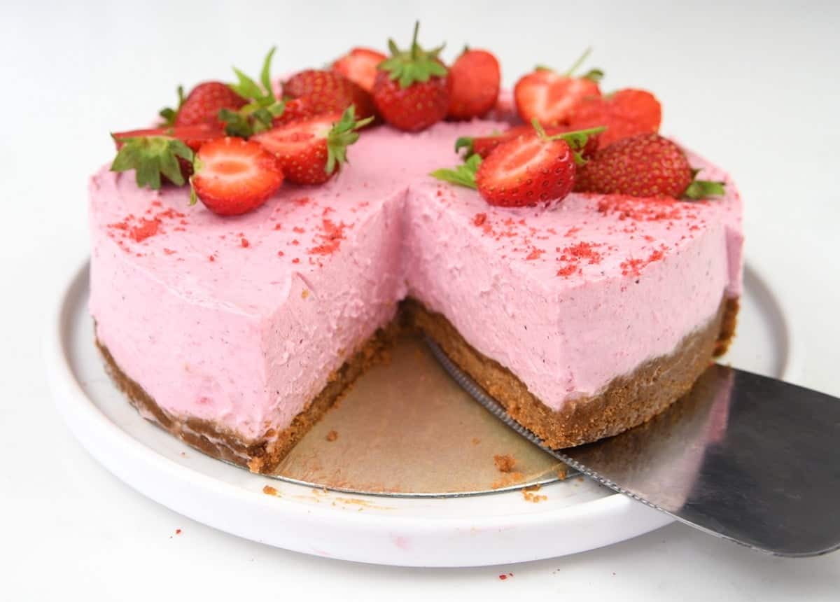 Slicing a no bake strawberry cheesecake