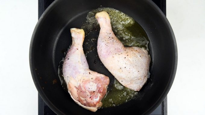 Browning chicken legs in a pan