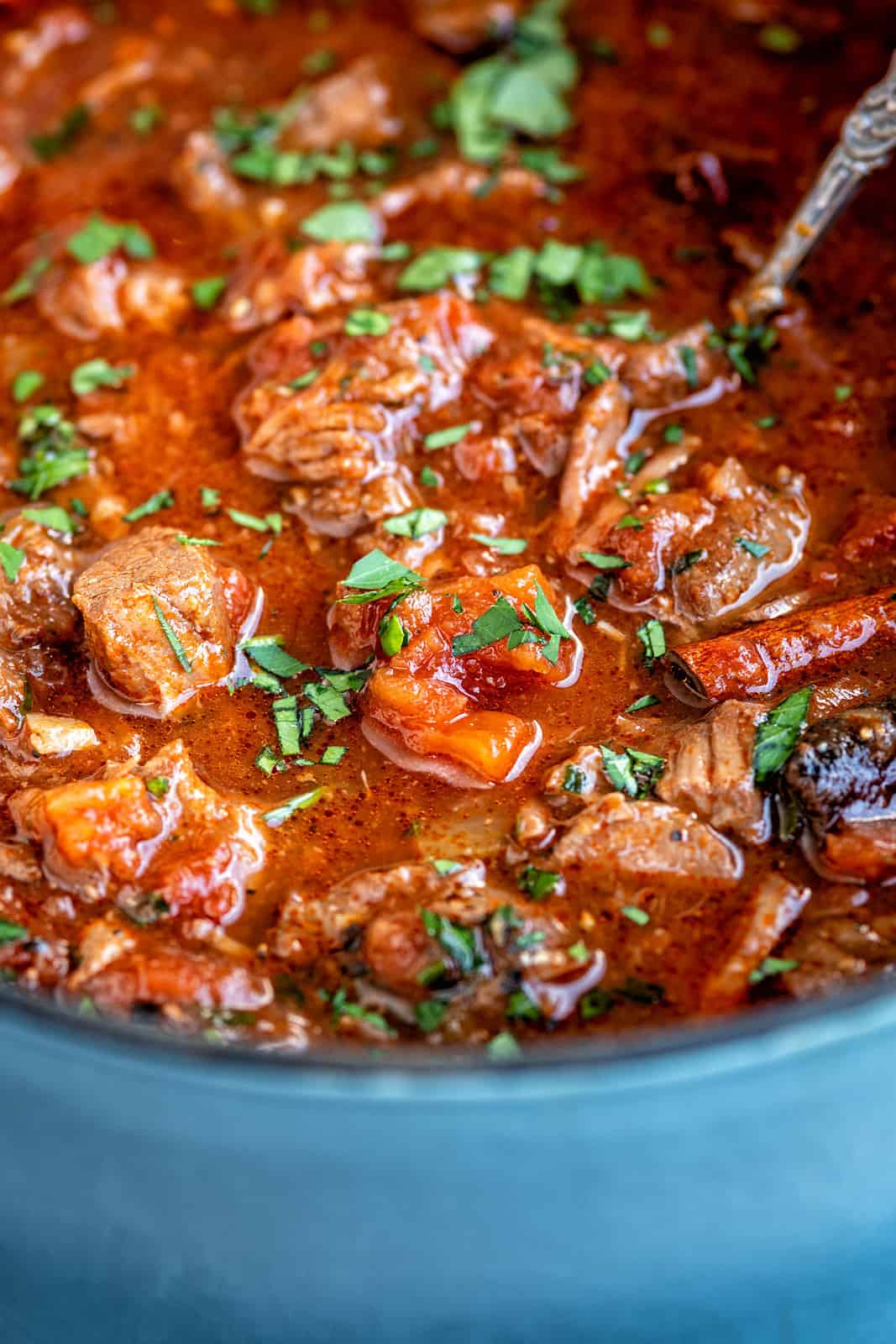 Greek beef stew with tomatoes and red wine in a blue pot