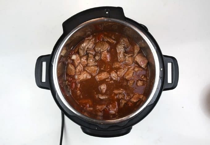 Red wine, tomatoes and cubed beef in an Instant Pot