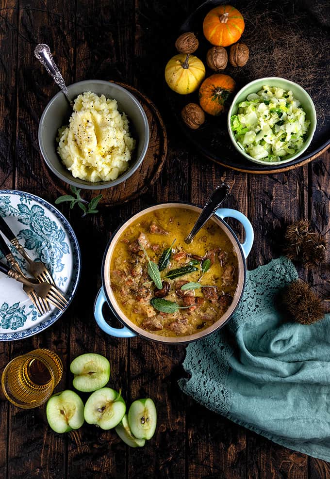 French pork casserole with cider and apples in a cast iron pot