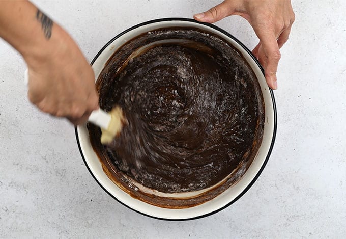 stirring brownie batter in a mixing bowl