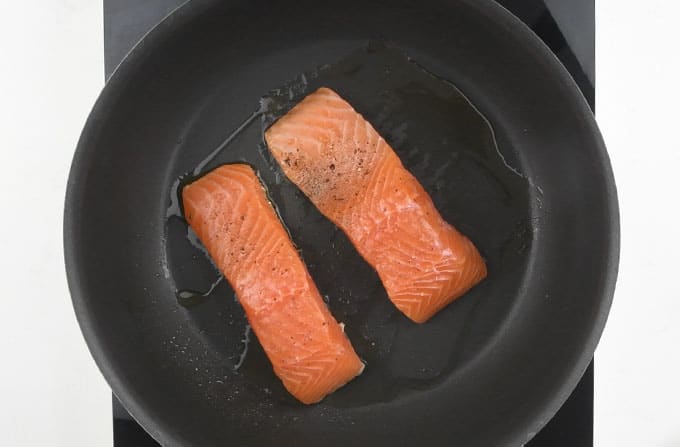Searing salmon fillets in a pan